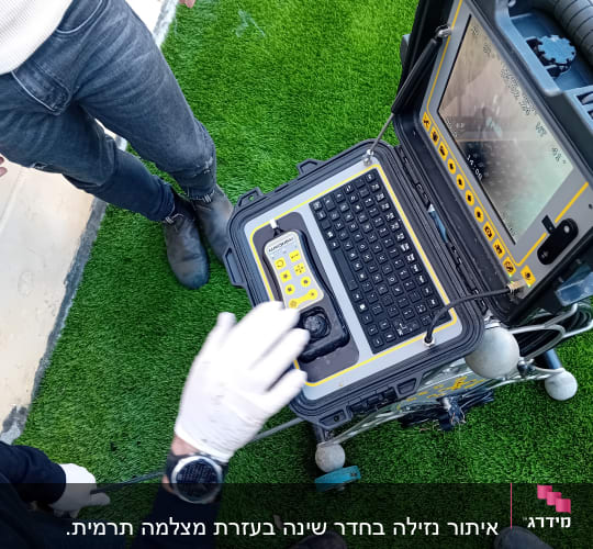מכשיר איתור נזילות עם מסך ומקלדת על דשא